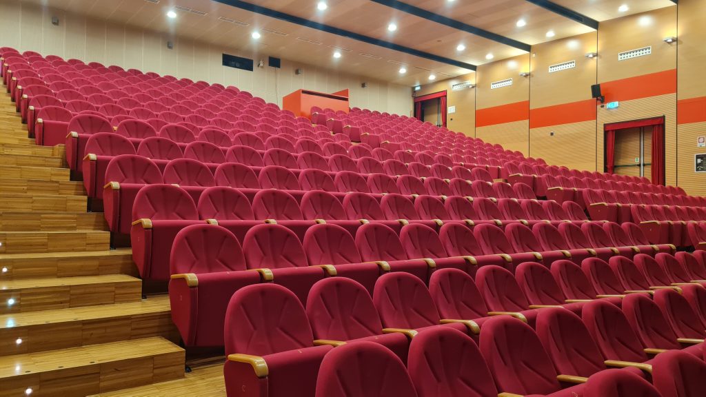 Auditorium moderno con sedili rossi.