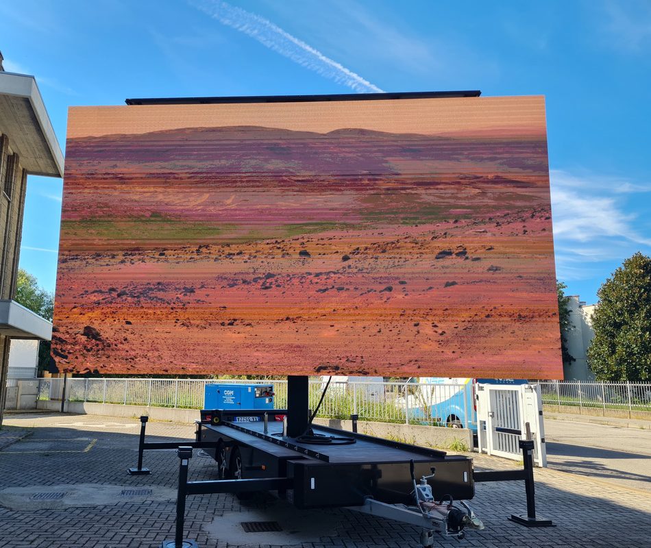 Maxischermo all'aperto con proiezione paesaggio desertico.